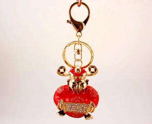 Detail of God of Wealth keychain with red enamel and sparkling crystal rhinestones