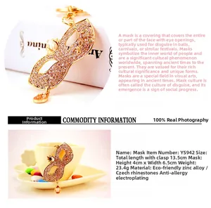 Detailed view of crystal masked keychain with golden finish and amber teardrop gemstone
