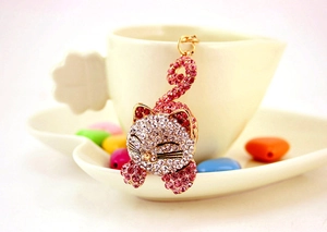 Détail d'un porte-clés chat mignon avec des strass roses et blancs sur métal doré