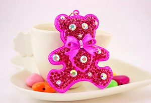Detail of a bright pink rhinestone bear keychain with crystal accents and gold hardware