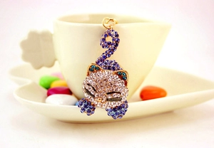Détail du porte-clés chat mignon avec strass violets sur une tasse à café
