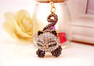 Vue macro d'un porte-clés chat endormi avec des strass blancs et gris anthracite