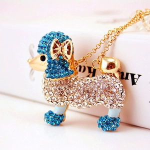 Joli collier pendentif caniche doré avec cristaux bleus et un élégant nœud doré scintillant