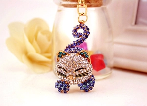 Détails macro d'un porte-clés chat en cristal avec strass blancs et violets brillants
