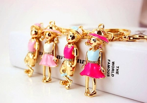 Close-up of four colorful cartoon couple keychains with crystal rhinestones and gold rings