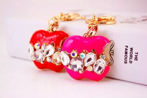 Détails macro de porte-clés en forme de pomme en cristal rouge et rose avec dorure