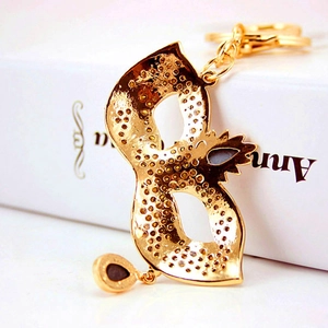 Creative crystal mask keychain in gold finish with water drop pendant on a gift box