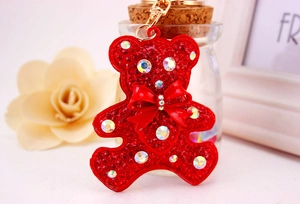 Detail of red rhinestone teddy bear keychain with gold lobster clasp and bow accessory
