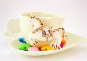 Dettaglio del portachiavi a cavallo con intarsio in resina crema e strass lucidi