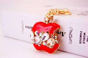 Détail d'un porte-clés pomme en cristal rouge avec métal doré et strass brillants