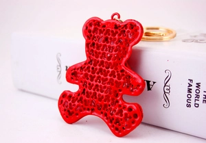 Detail of red bear keychain with unique honeycomb hollow design and golden metal ring