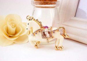Dettaglio portachiavi a forma di cavallo panna con strass e finiture dorate lusso