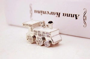 Silver vintage steam train keychain with white crystals and enamel on a book background