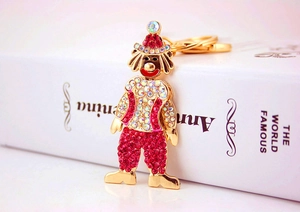 Dettaglio portachiavi clown creativo con base dorata lucida e strass rossi brillanti
