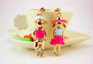 Close-up of cute couple keychain pendants with rhinestones on a white coffee cup