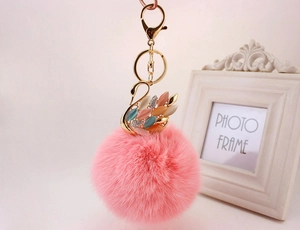Dettaglio di un portachiavi a cigno con strass colorati e una soffice palla di pelo rosa