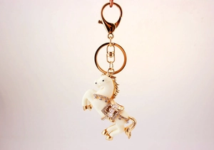 Dettaglio del portachiavi a forma di cavallo con strass e finiture placcate oro