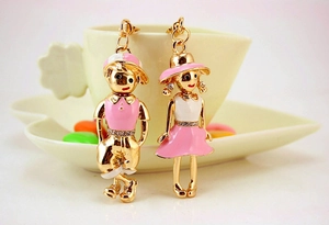 Close-up of cute cartoon couple keychains with pink enamel and sparkling rhinestones