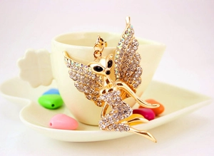 Detail eines Feen Schmetterling Schlüsselanhängers mit Kristallen auf einer Kaffeetasse