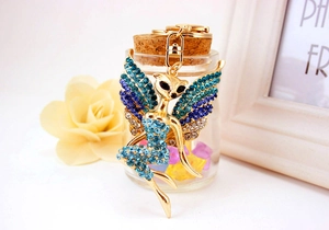 Detailaufnahme eines goldenen Blumenfee-Schlüsselanhängers mit bunten Strasssteinen und Karabiner