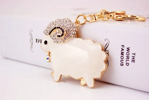 Detail of rhinestone sheep keychain with white enamel and golden D-ring clasp