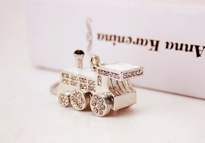 Detail of silver train keychain with sparkling rhinestones and white enamel finish