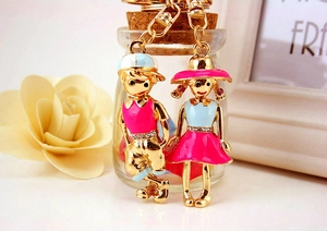 Detail of cartoon couple keychains featuring colorful enamel dolls and sparkling rhinestones