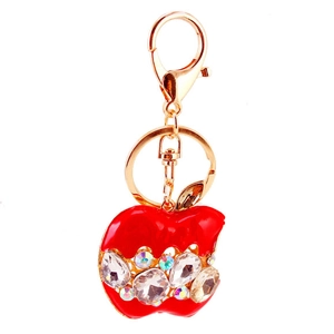 Porte-clés pomme en cristal rouge avec strass brillants et mousqueton doré sur fond blanc