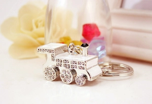 Macro shot of silver train keychain with rhinestones and white enamel finish