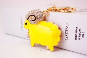 Close-up of yellow sheep keychain with sparkling rhinestones and golden metal lobster clasp