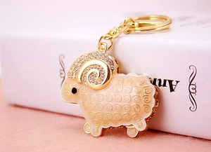 Close-up of goat keychain with rhinestones and cream enamel finish on golden alloy