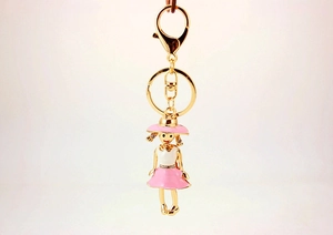 Detail of pink enamel girl pendant with rhinestones and gold lobster clasp keychain