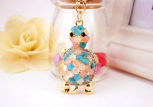 Detailed macro view of turtle keychain showing opal shell stones and shiny rhinestones