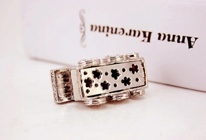 Close-up of silver metal keychain with floral cutouts and sparkling zircon accents
