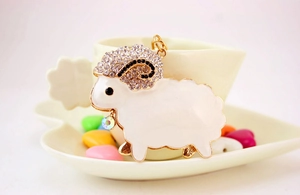 Close-up of sheep keychain with white enamel, crystal rhinestones and golden metal details
