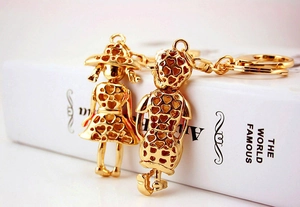 Close-up of gold-plated boy and girl couple keychains with hollow heart patterns