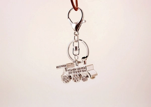 Detailed close-up of a silver steam train keychain with sparkling white rhinestones