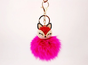 Detail of fox pendant with pink rhinestones, white pearls, and a fluffy rose red fur ball