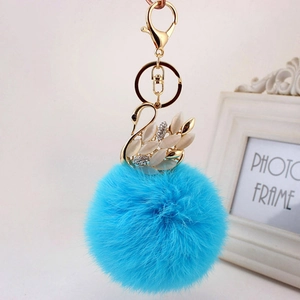 Portachiavi pompon azzurro in ecopelliccia con ciondolo a cigno e strass dorati