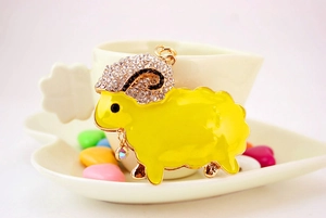 Macro detail of cute sheep keychain with sparkling rhinestones and yellow enamel finish