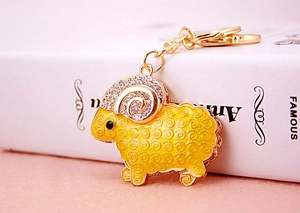 Close-up of golden sheep keychain with sparkling white rhinestones and yellow enamel texture