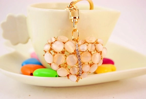 Macro-opname van 3D hart sleutelhanger met roze opalen en strass op gouden ring