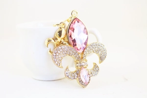 Dettaglio del ciondolo a fiore di iris dorato con cristalli marquise rosa e strass luccicanti