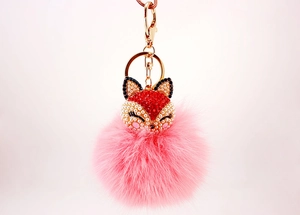 Detailed view of pink fluffy fox head keychain with rhinestones and golden hardware