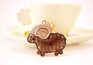 Detail of goat keychain with gold alloy edges, brown enamel body, and white rhinestones