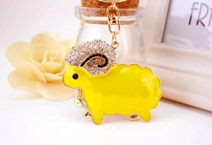 Macro detail of cute yellow sheep keychain featuring sparkling rhinestones and gold clasp
