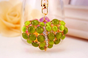 Detail van hartvormige sleutelhanger met groene opaal en witte strass-steentjes
