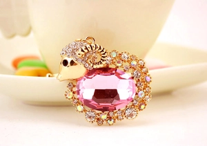 Close-up of pink crystal goat keychain with gold-plated metal and inlaid rhinestones