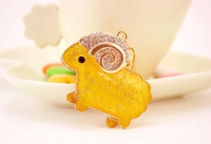 Detail of goat keychain with yellow enamel body and sparkling rhinestone horns