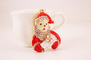 Macro view of rhinestone Santa Claus keychain with red enamel finish and gift box detail